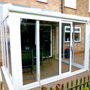 white patio doors opening to a sunroom